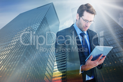 Composite image of businessman using a tablet computer