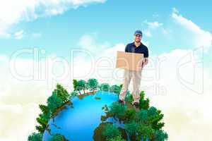 Composite image of happy delivery man holding cardboard box