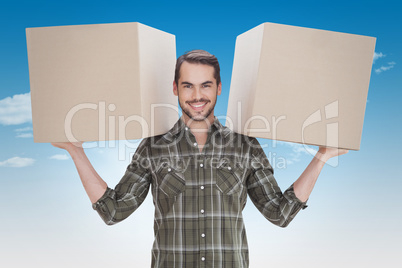 Composite image of happy man holding boxes