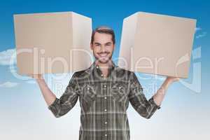 Composite image of happy man holding boxes