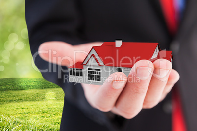 Composite image of businessman presenting with his hand