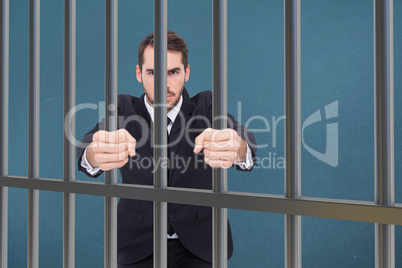 Composite image of angry businessman standing with clenched fist