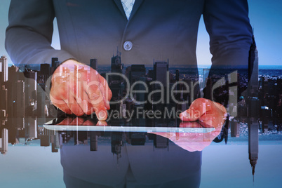 Composite image of businessman using his tablet pc