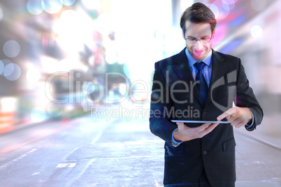 Composite image of businessman standing while using a tablet pc