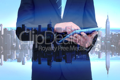 Composite image of businessman touching his tablet pc