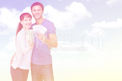 Composite image of couple holding fans of cash