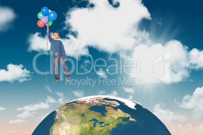 Composite image of cute boy holding balloons