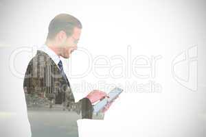 Composite image of businessman in reading glasses using his tabl