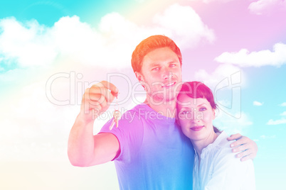 Composite image of couple holding keys to home