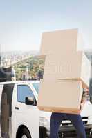 Composite image of man carrying pile of boxes