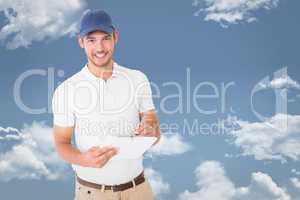 Composite image of happy delivery man holding clipboard