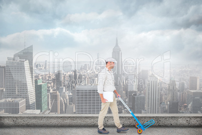 Composite image of delivery man pushing empty trolley on white b