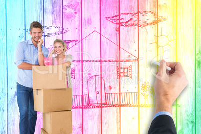 Composite image of attractive young couple leaning on boxes with