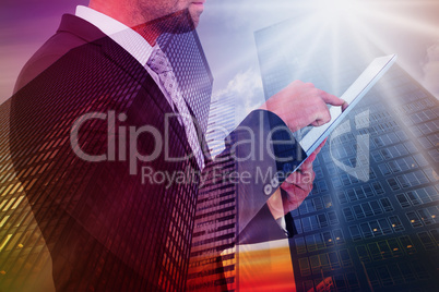 Composite image of businessman using his tablet pc