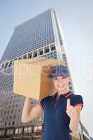 Composite image of happy delivery woman holding cardboard box sh
