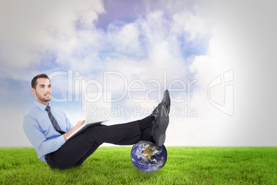 Composite image of businessman using laptop