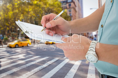 Composite image of delivery man writing on clipboard