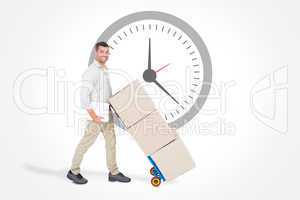 Composite image of happy delivery man pushing trolley of boxes