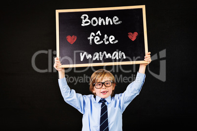 Composite image of cute pupil holding chalkboard