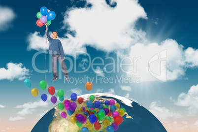 Composite image of cute boy holding balloons