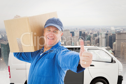 Composite image of happy delivery man holding cardboard box