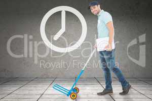 Composite image of confident delivery man pushing empty trolley