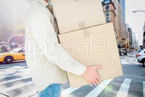 Composite image of delivery man carrying cardboard boxes