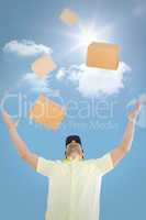 Composite image of delivery man with arms raised