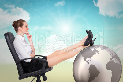 Composite image of businesswoman sitting on swivel chair with fe