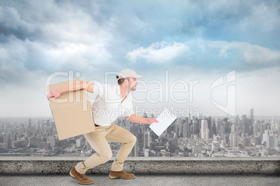 Composite image of delivery man with cardboard box