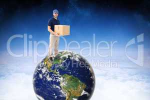 Composite image of happy delivery man holding cardboard box