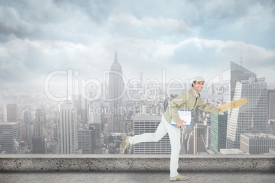 Composite image of happy delivery man running while holding parc