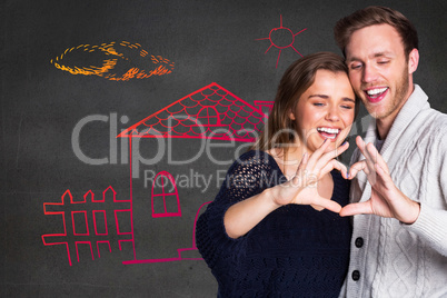 Composite image of happy couple forming heart with hands