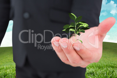 Composite image of businessman holding out his hand