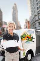 Composite image of happy flower delivery woman looking for signa