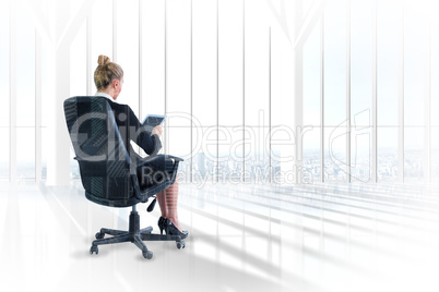 Composite image of businesswoman sitting on swivel chair with ta