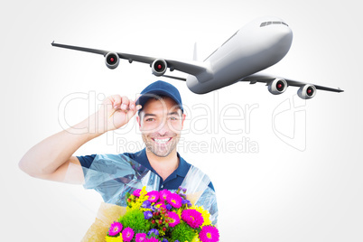 Composite image of happy delivery man holding bouquet