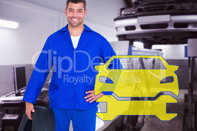 Composite image of smiling male mechanic holding tire