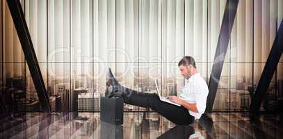 Composite image of businessman with feet up on briefcase