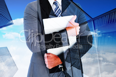 Composite image of businessman holding his laptop tightly