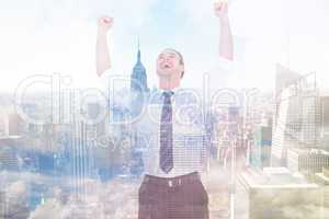 Composite image of handsome businessman cheering with arms up