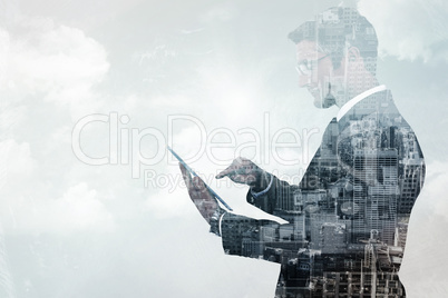 Composite image of mid section of a businessman touching tablet