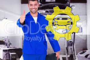 Composite image of mechanic with tire gesturing thumbs up