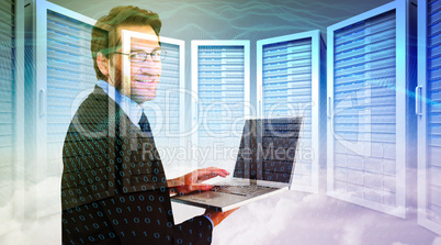 Composite image of smiling businessman using a laptop