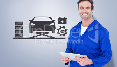 Composite image of handsome mechanic holding digital tablet