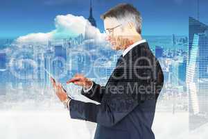 Composite image of mid section of a businessman touching tablet