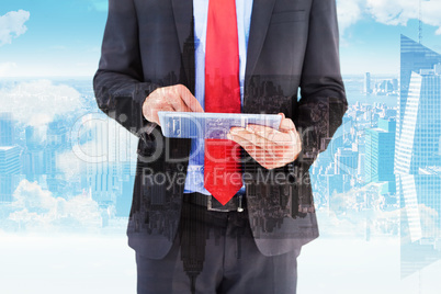 Composite image of businessman scrolling on his digital tablet