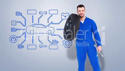 Composite image of smiling male mechanic holding tire