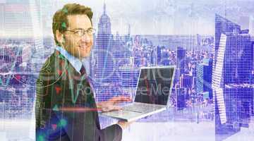 Composite image of smiling businessman using a laptop