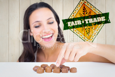 Composite image of pretty brunette picking out chocolate